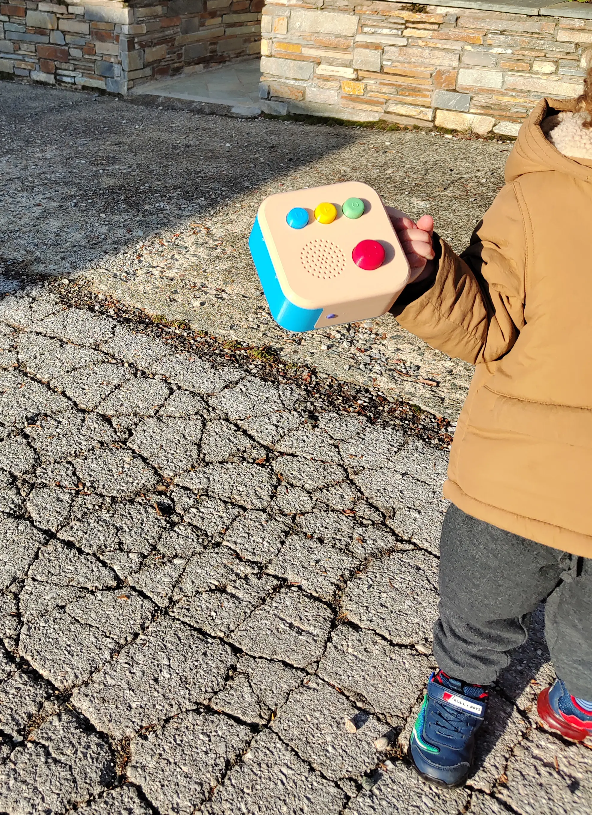 A toddler outdoors, holding a Koobiba