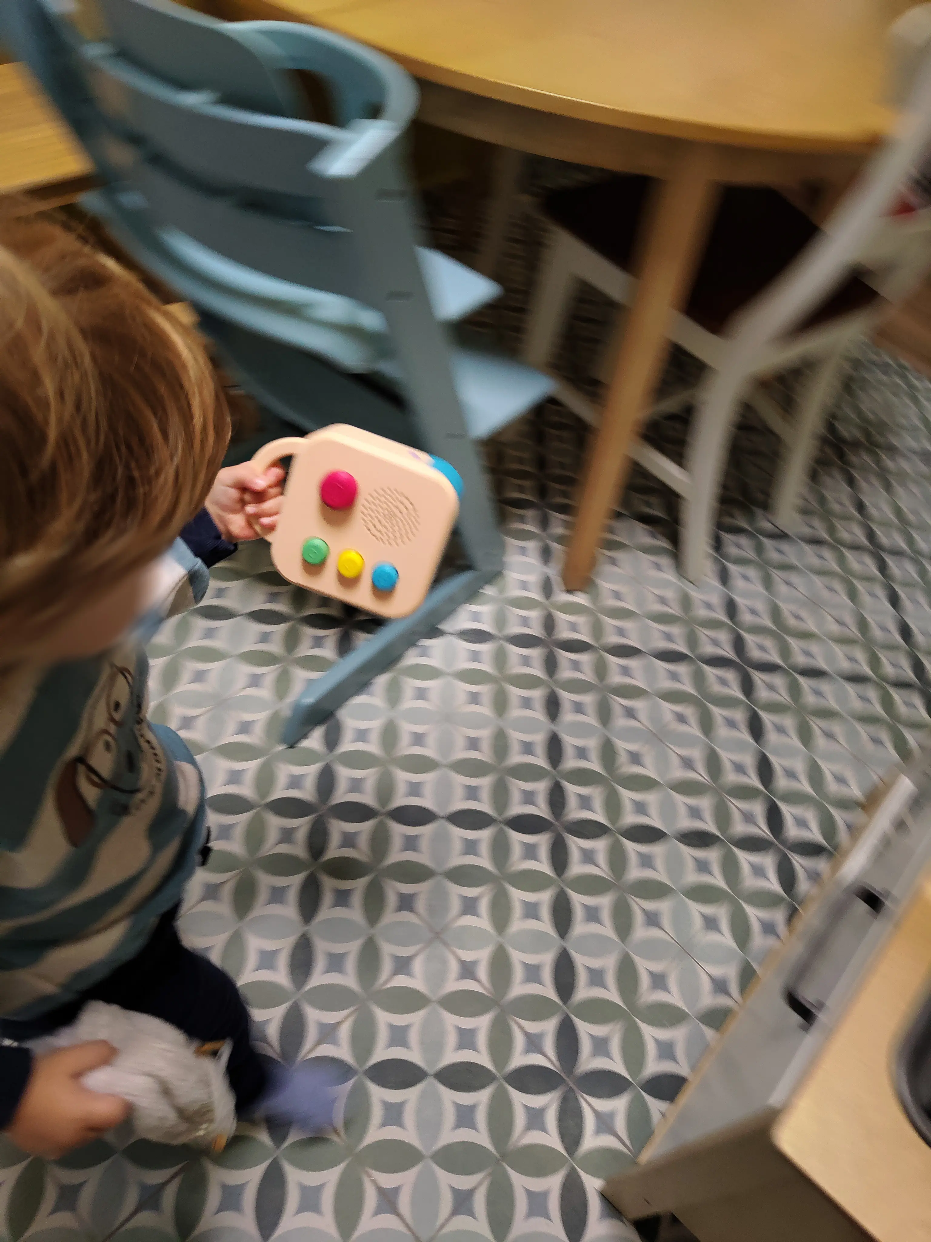 A toddler at home, holding a Koobiba