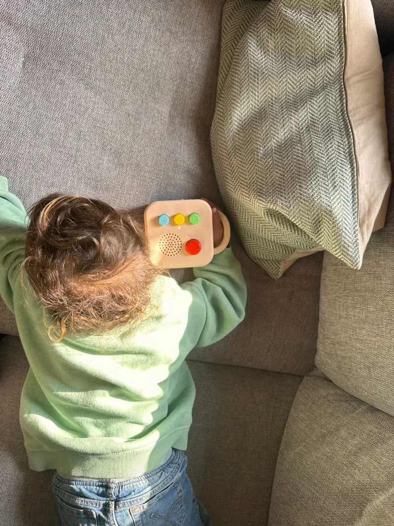 Child on a couch with a Koobiba audio player, listening independently